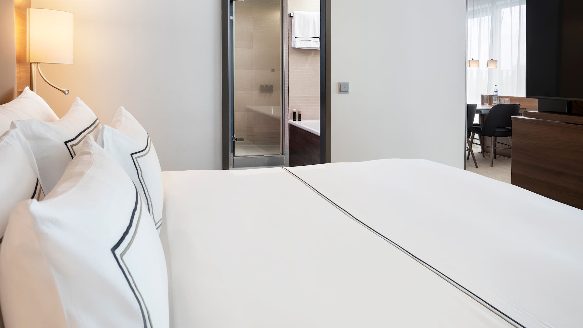 a bed with white sheets and a lamp