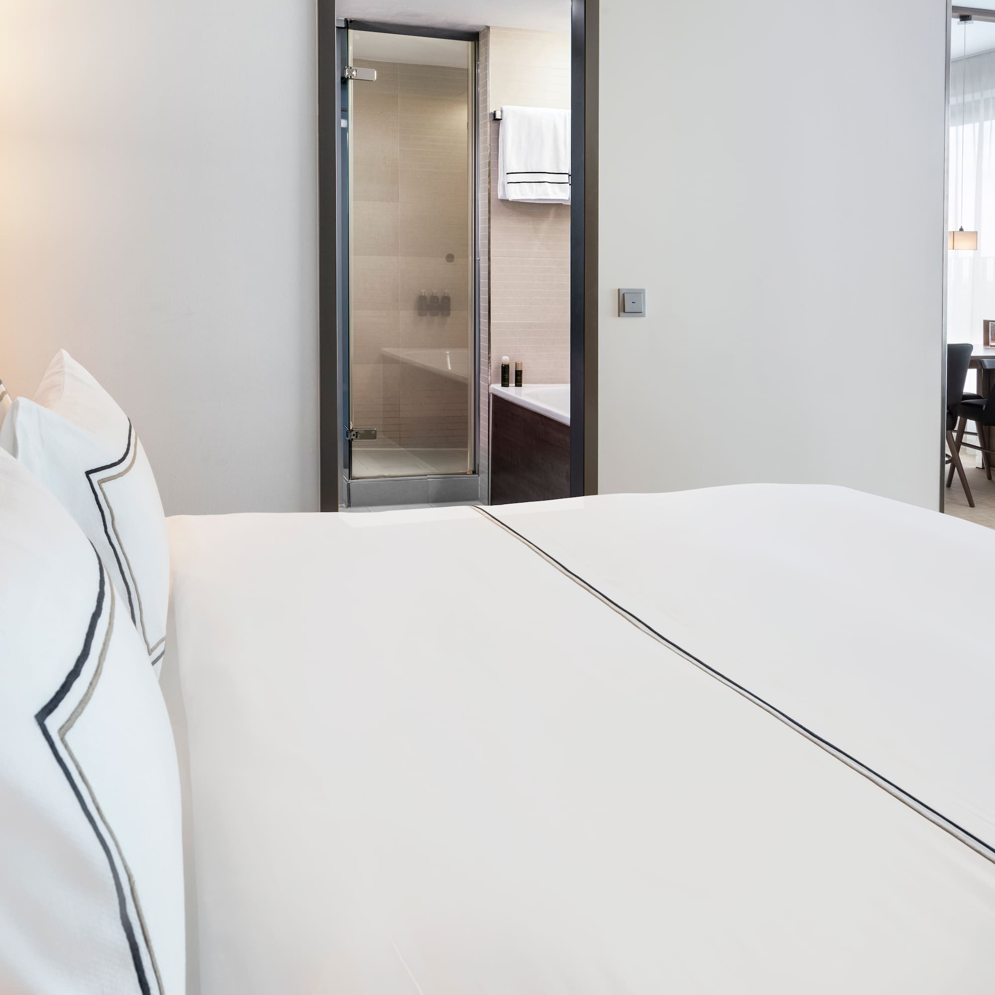 a bed with white sheets and a lamp