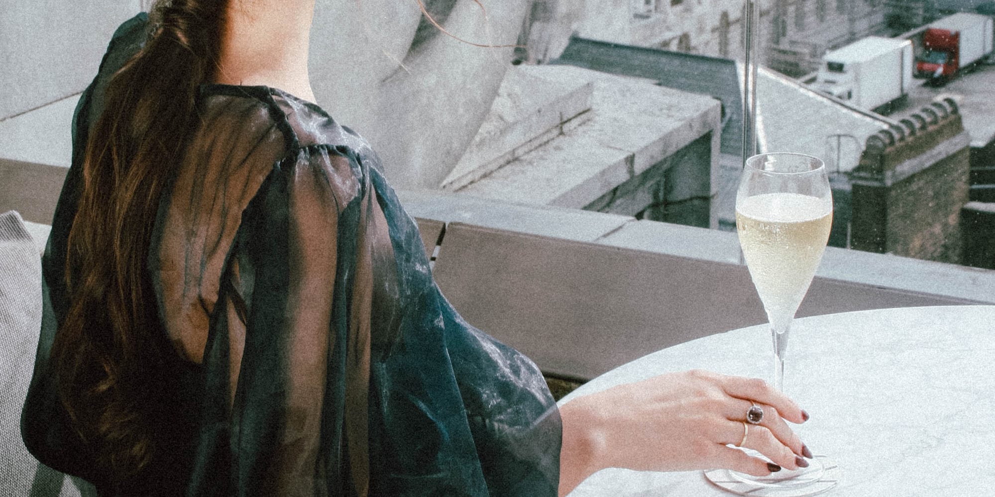 a woman sitting at a table with a glass of champagne