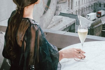a woman sitting at a table with a glass of champagne