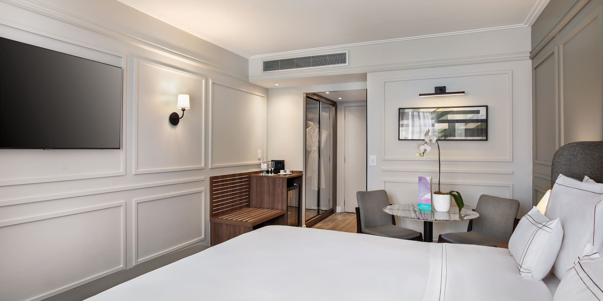 a room with a bed and chairs