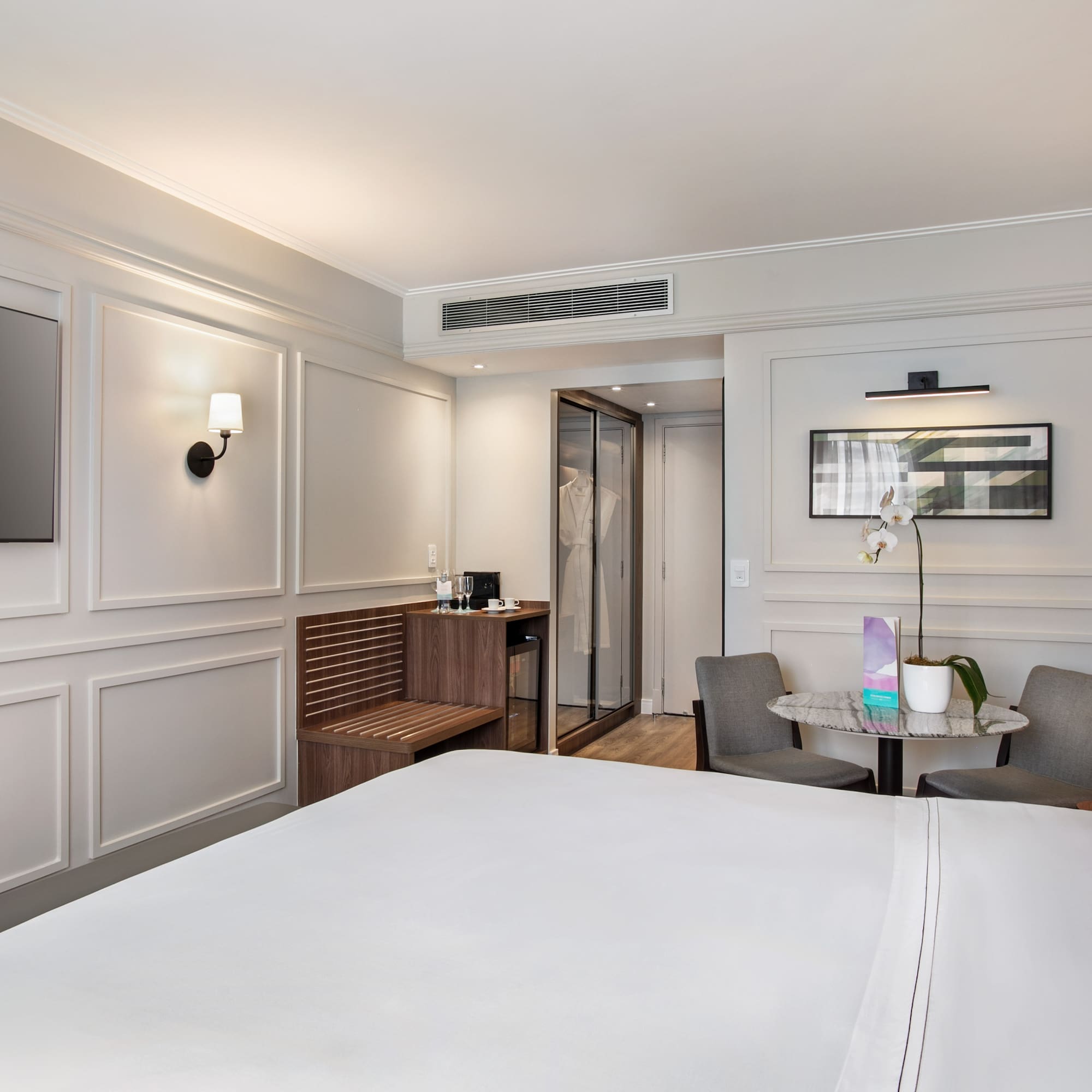 a room with a bed and chairs