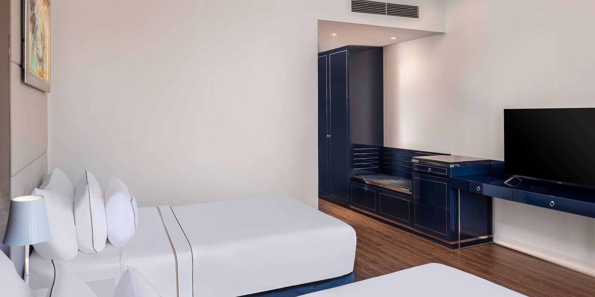 a room with white beds and a blue cabinet