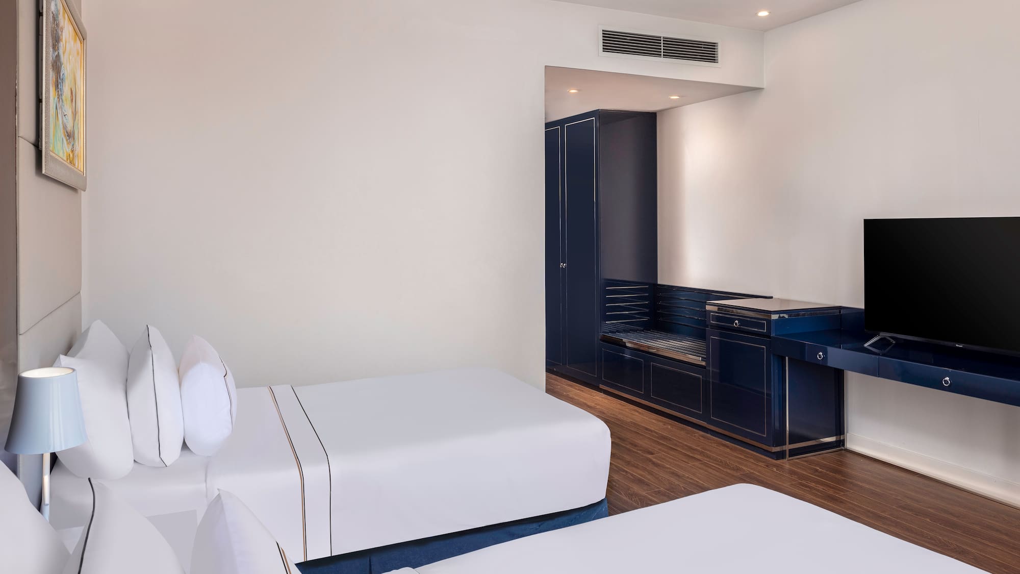 a room with white beds and a blue cabinet