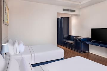 a room with white beds and a blue cabinet