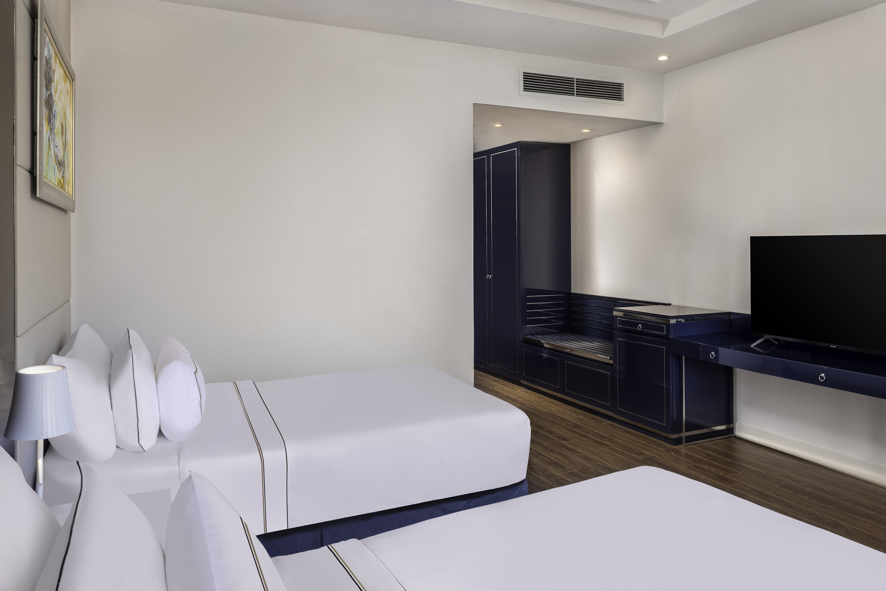 a room with white beds and a blue cabinet