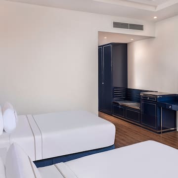 a room with white beds and a blue cabinet