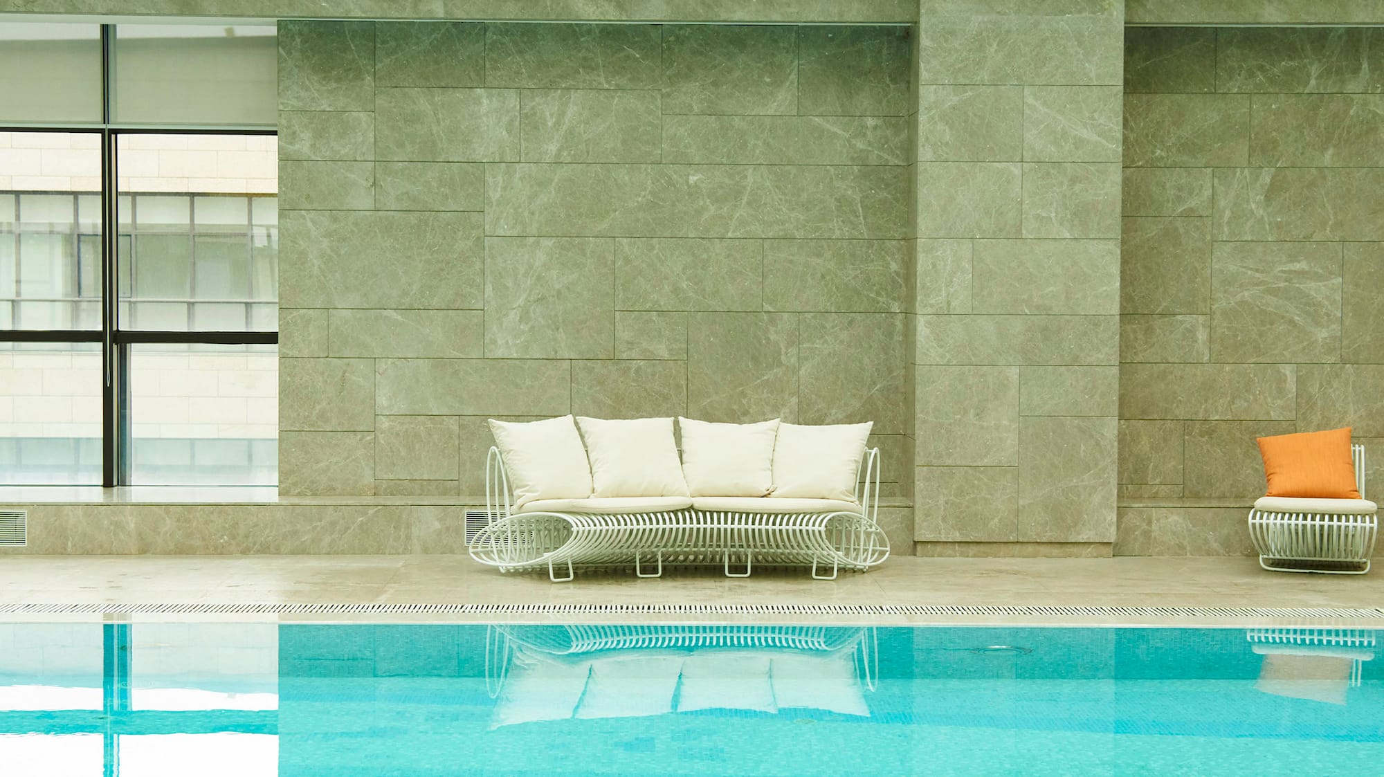 a pool with a couch and chairs