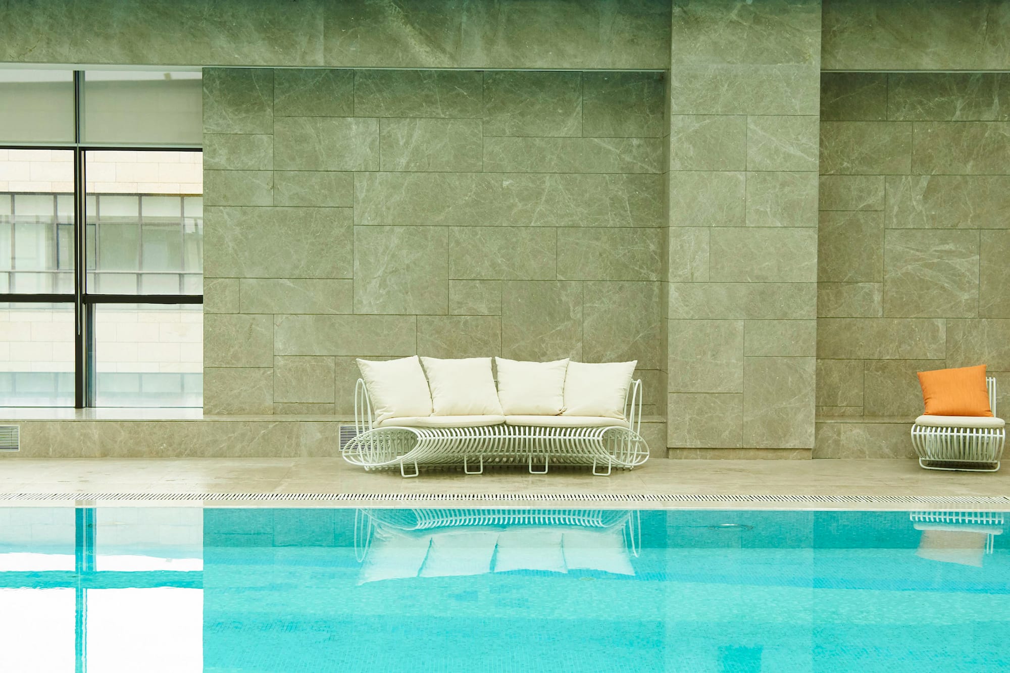 a pool with a couch and chairs