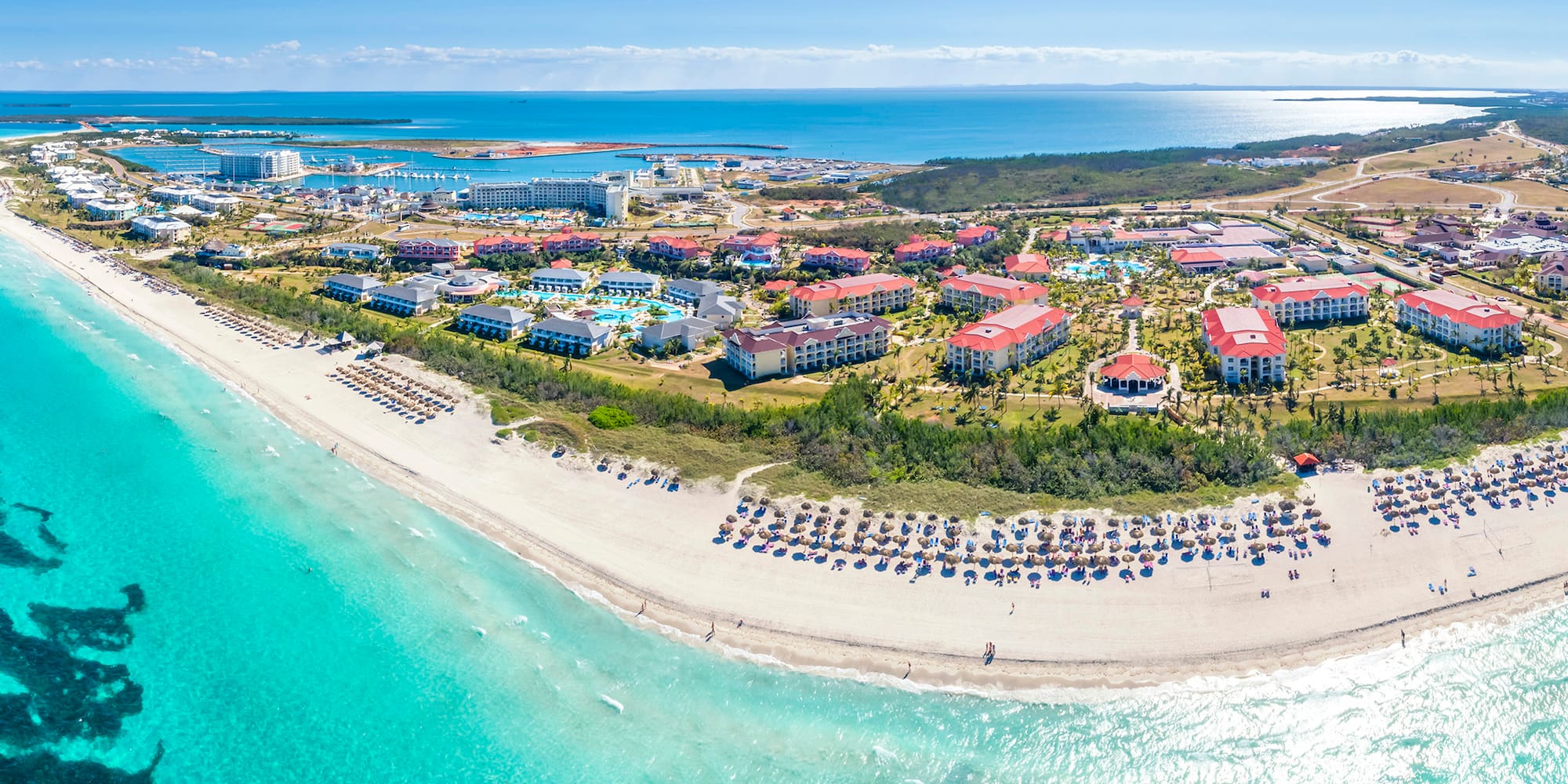 a beach with buildings and a body of water