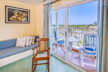 a room with a balcony and a couch and chairs