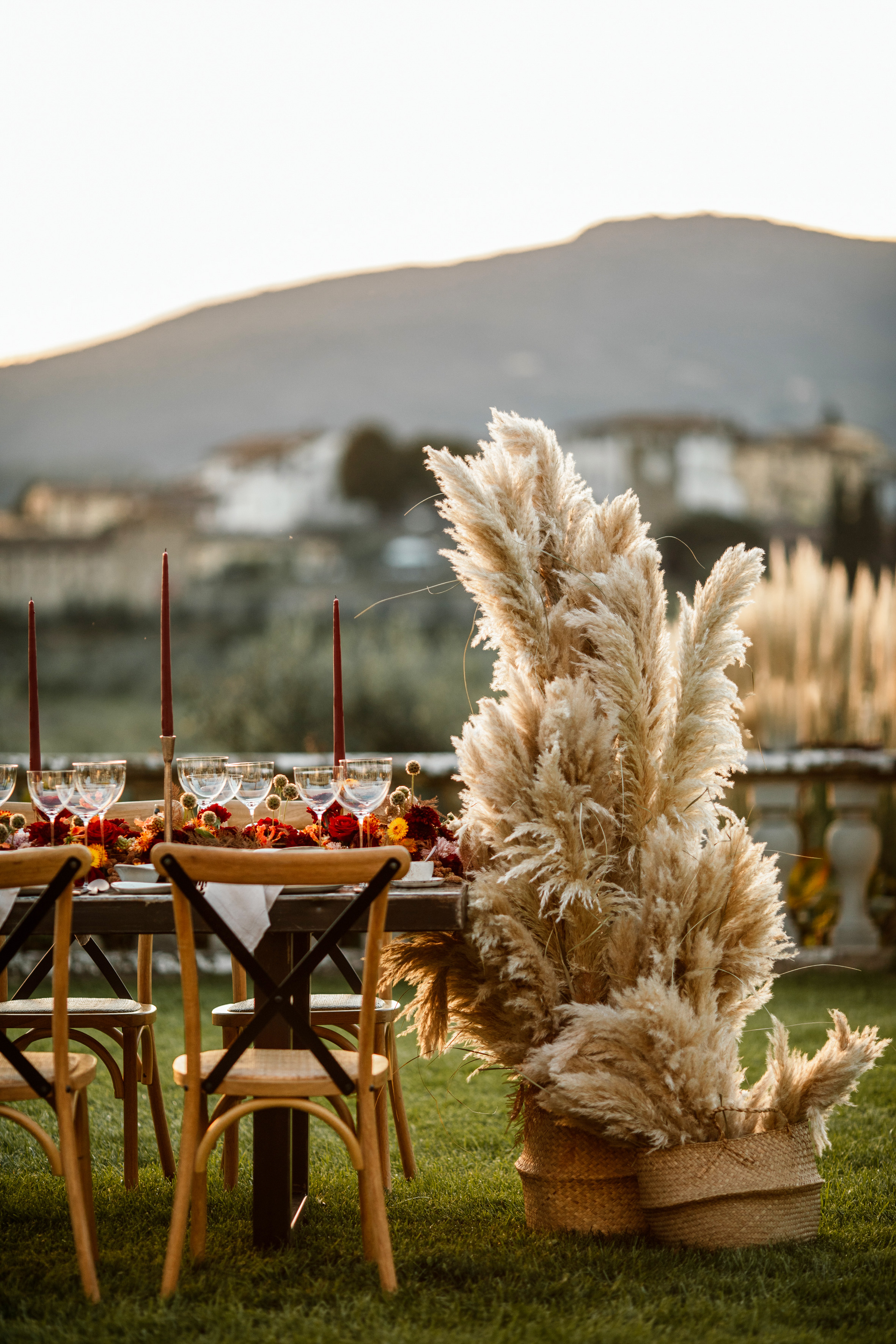 a table set with tall grass and flowers