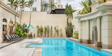 a swimming pool with chairs and trees