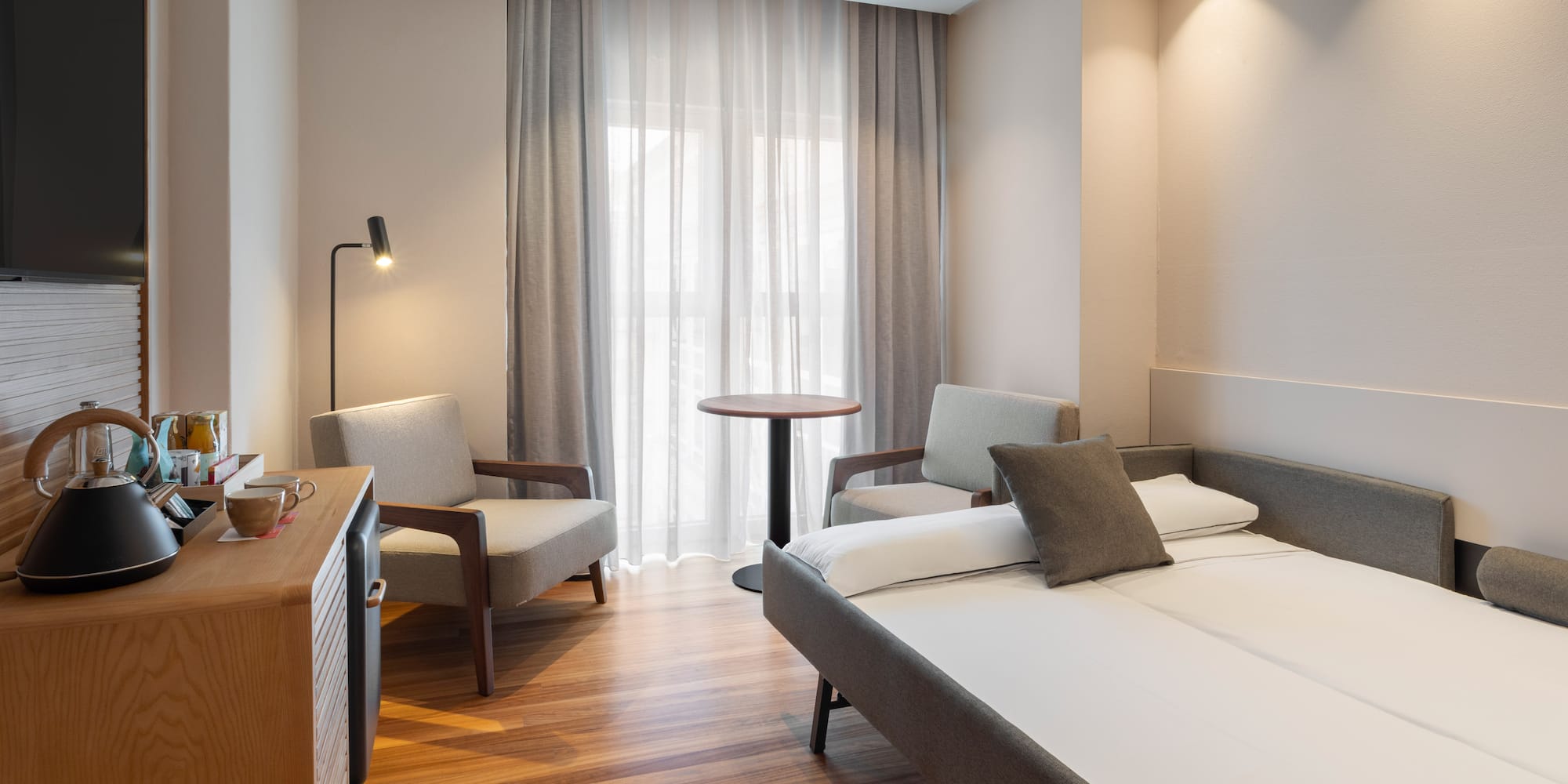 a room with a bed and chairs