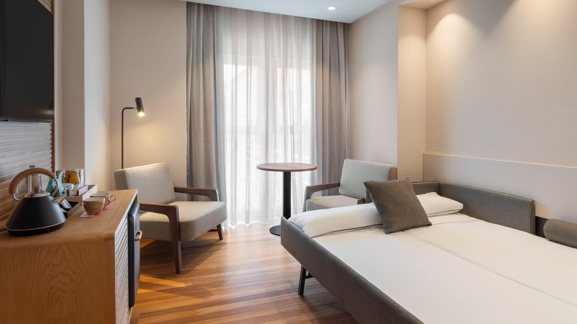 a room with a bed and chairs