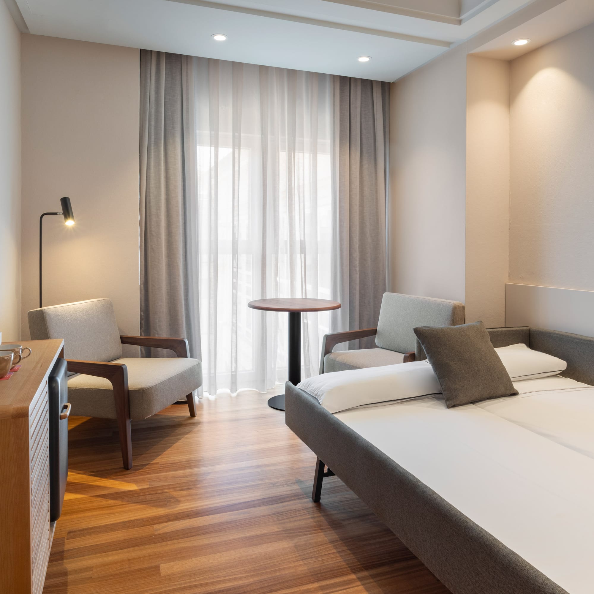 a room with a bed and chairs