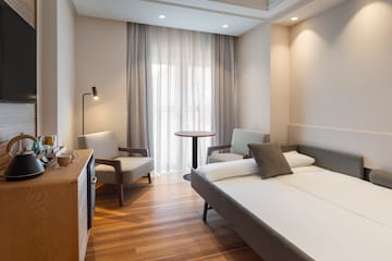 a room with a bed and chairs