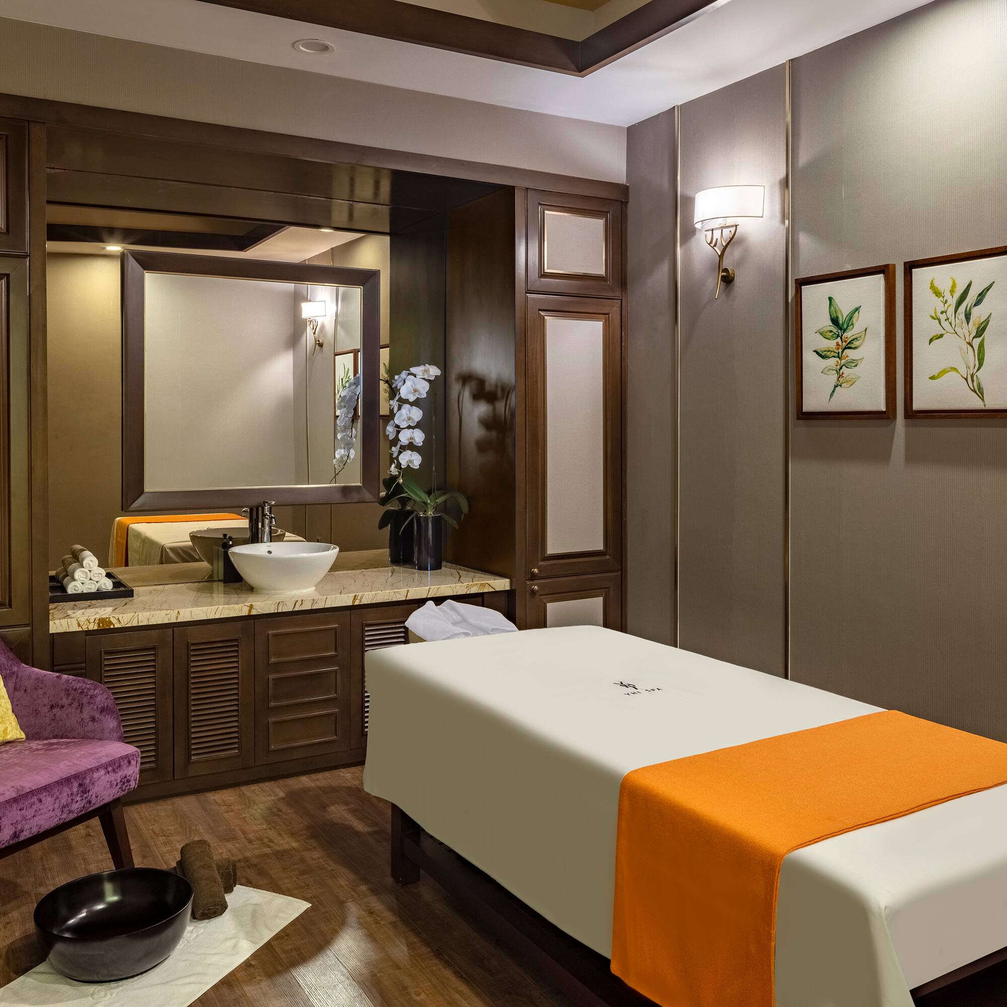 a room with a massage table and a purple chair