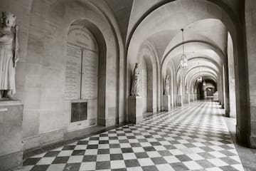 a long hallway with stone arches and statues
