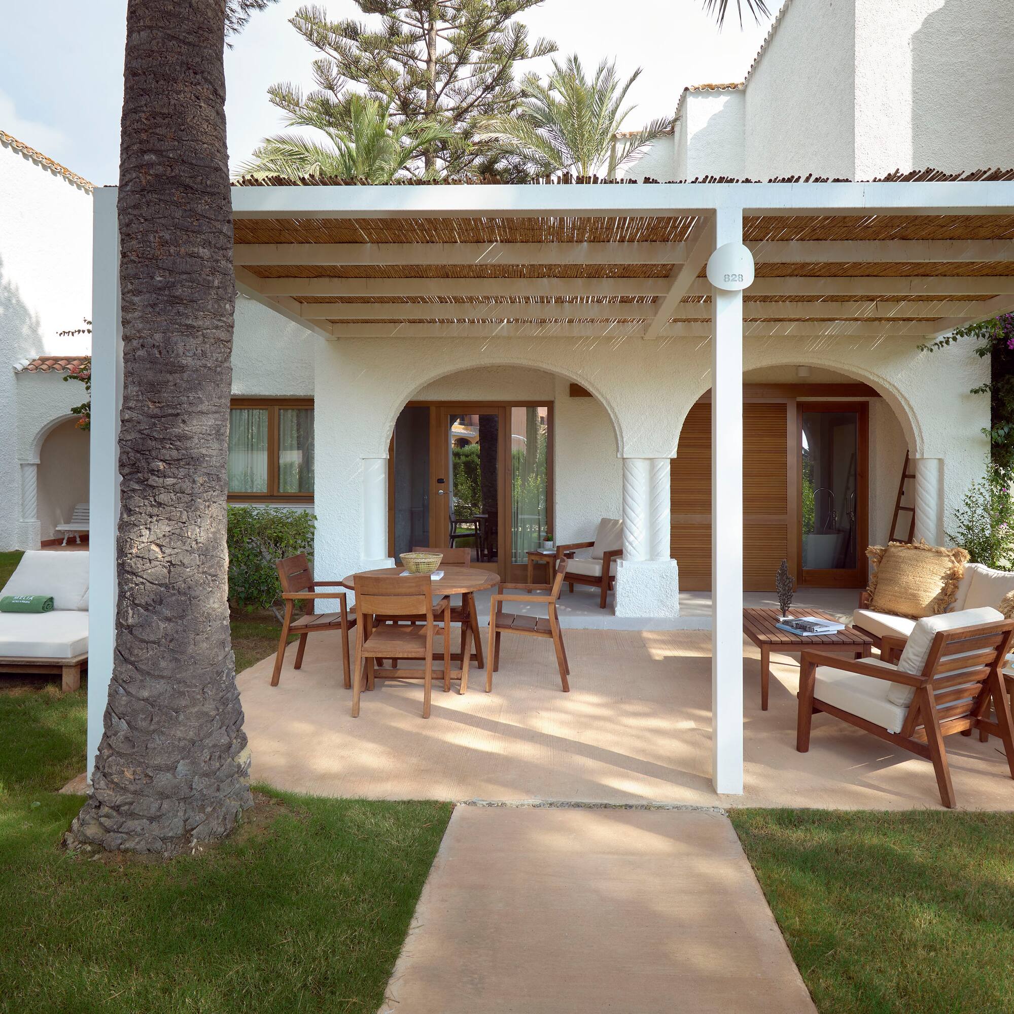 a patio with a covered patio and a tree