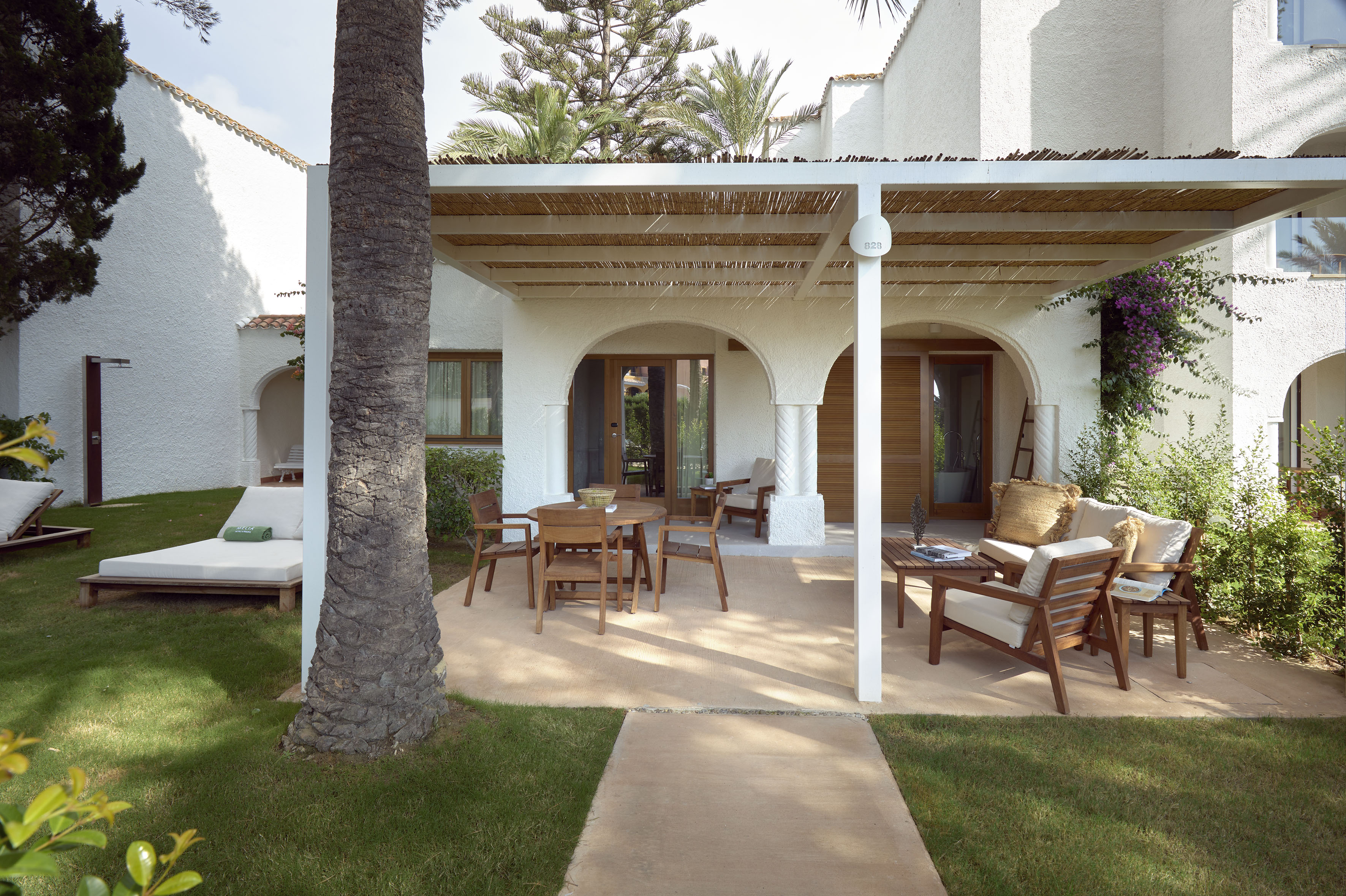 a patio with a covered patio and a tree