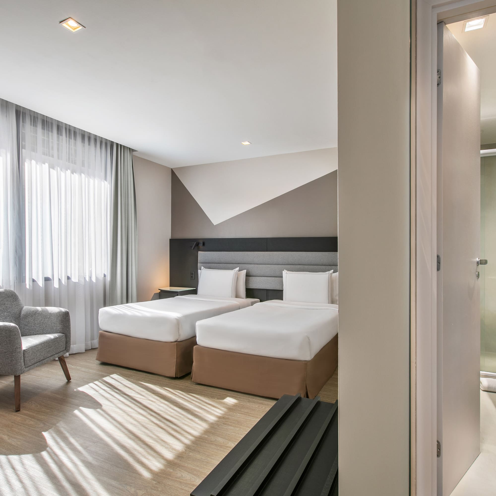 a room with two beds and a chair