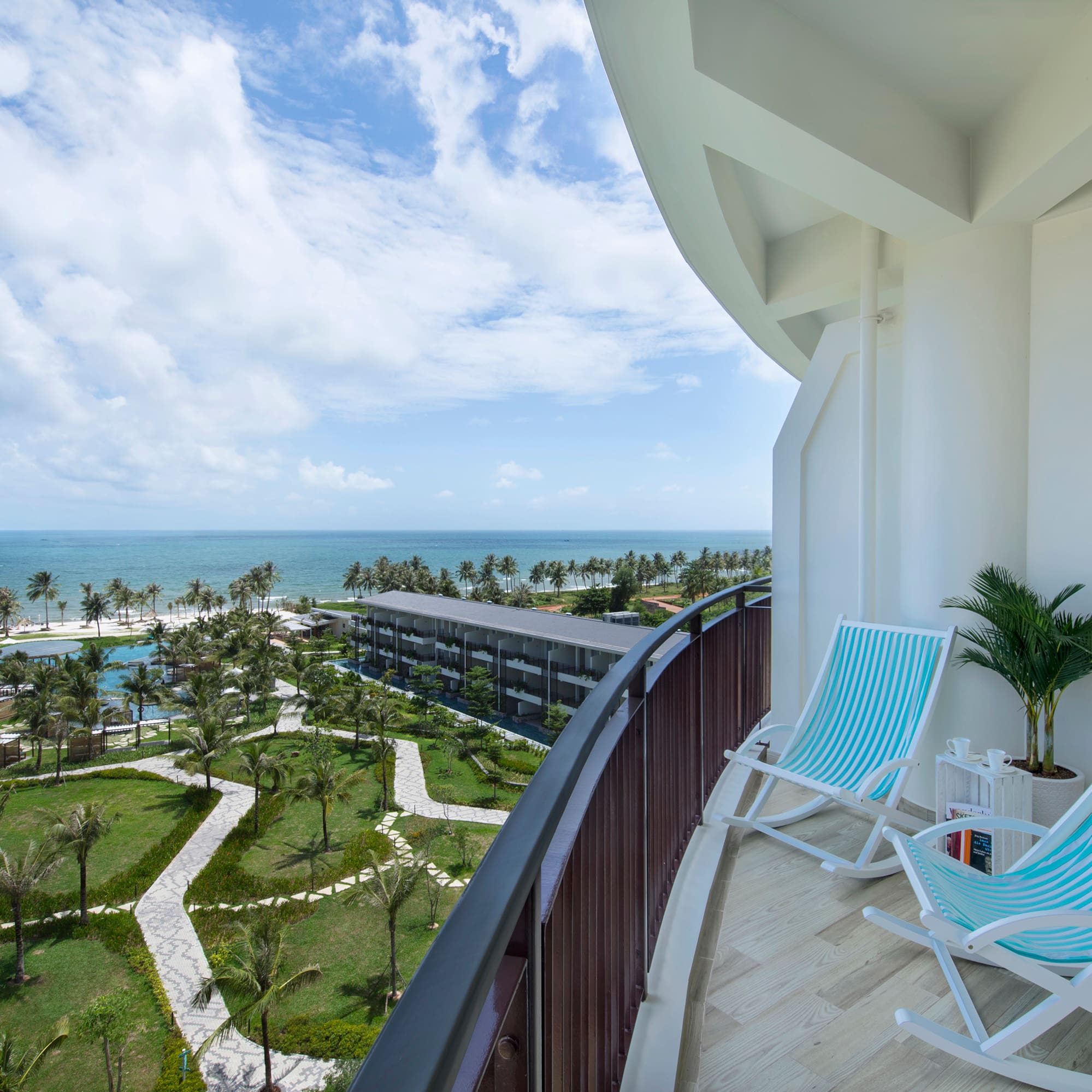 a deck with chairs and palm trees and a beach