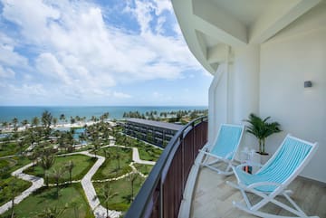 a deck with chairs and palm trees and a beach