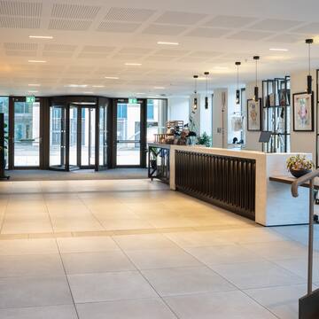 a lobby with a reception desk and glass doors