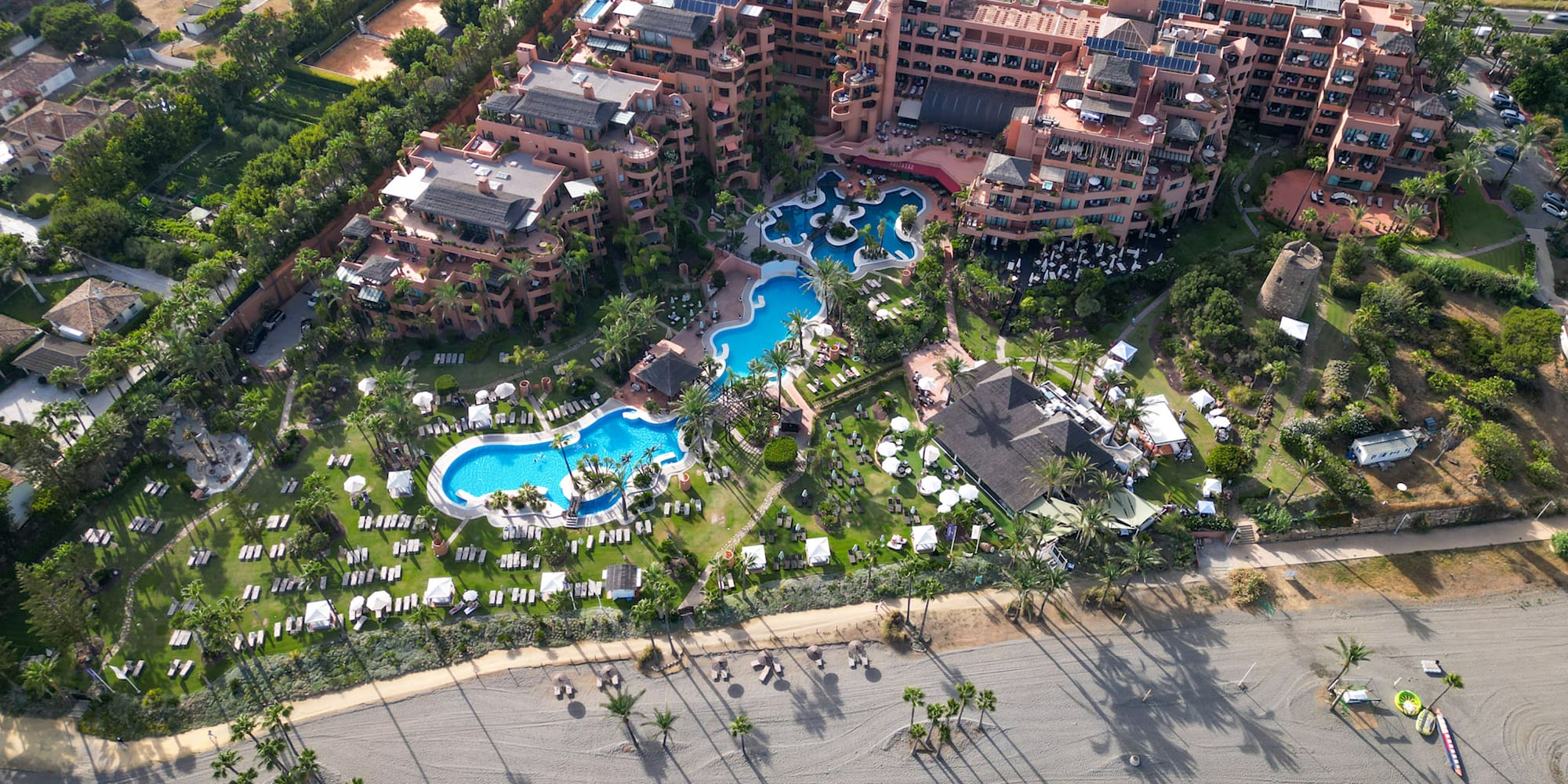 an aerial view of a resort with a pool and a beach