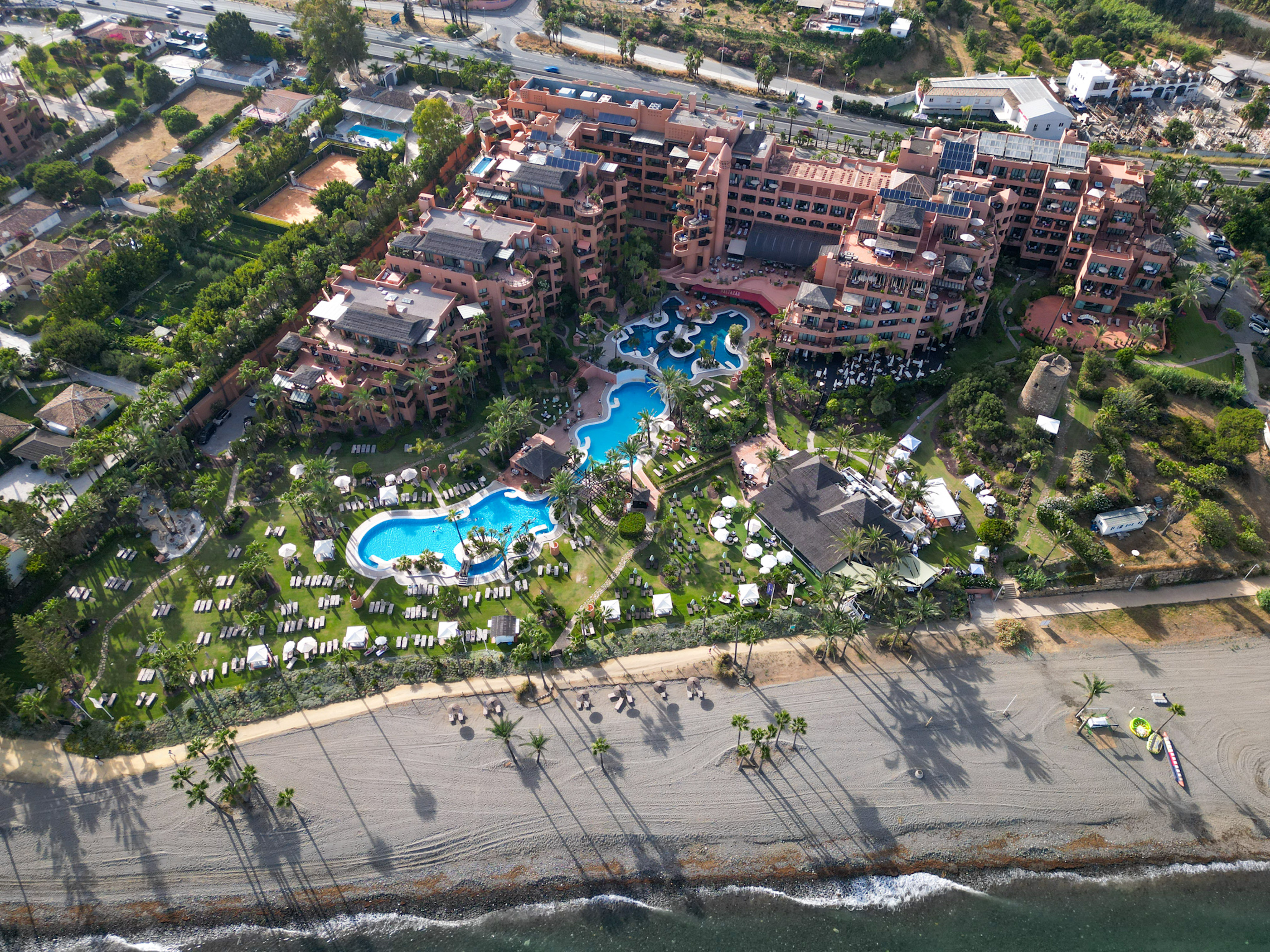 an aerial view of a resort with a pool and a beach