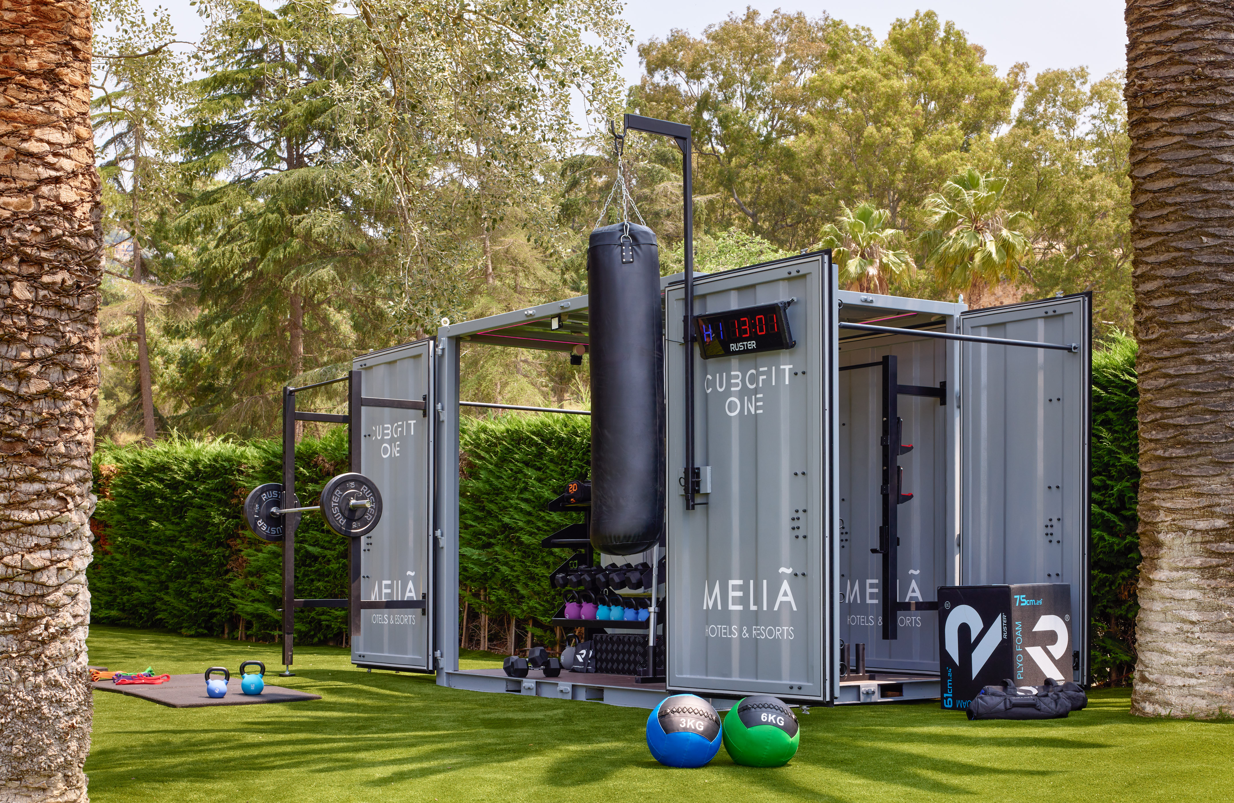 Cubcfit One outdoor gym at Meliã Hotels with boxing bag and weights on grass.