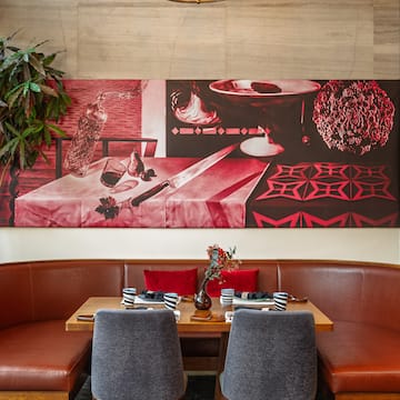 a table with chairs and a painting on the wall