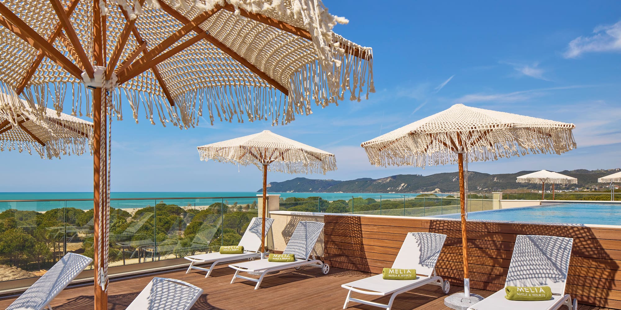 a deck with chairs and umbrellas on a sunny day