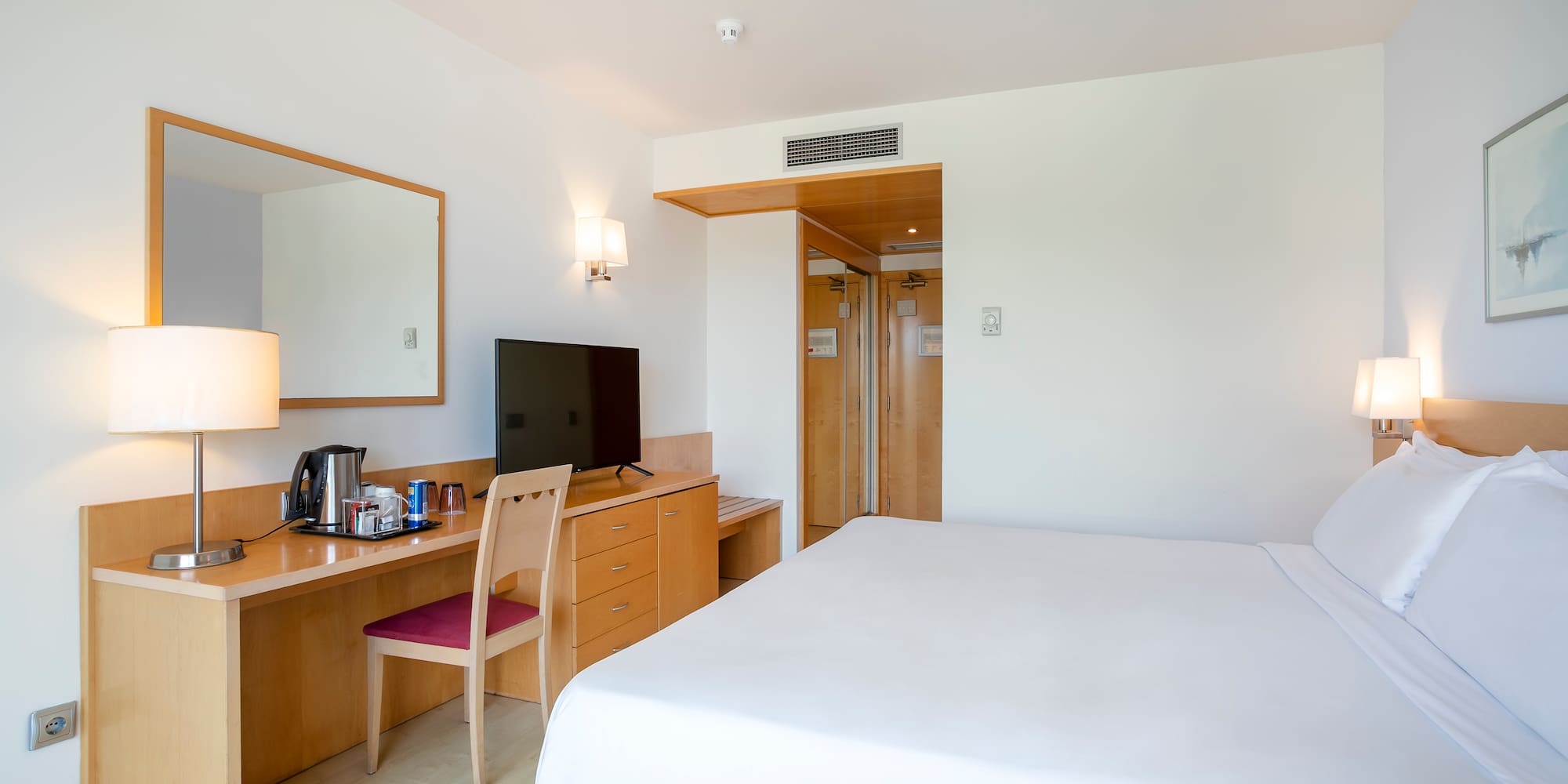 a room with a bed and a desk and a mirror