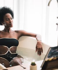 a woman in a bathtub holding a glass of wine
