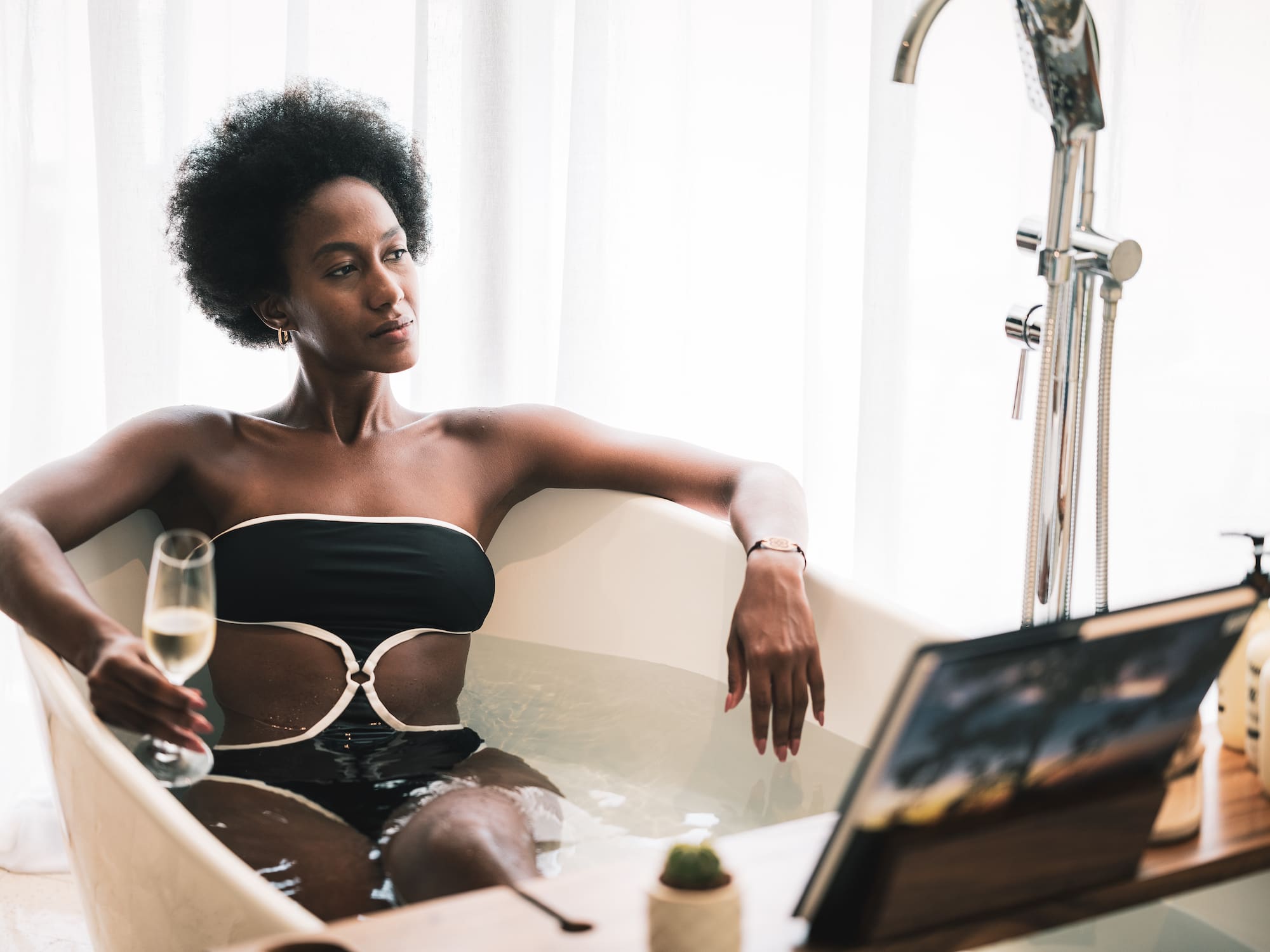 a woman in a bathtub holding a glass of wine