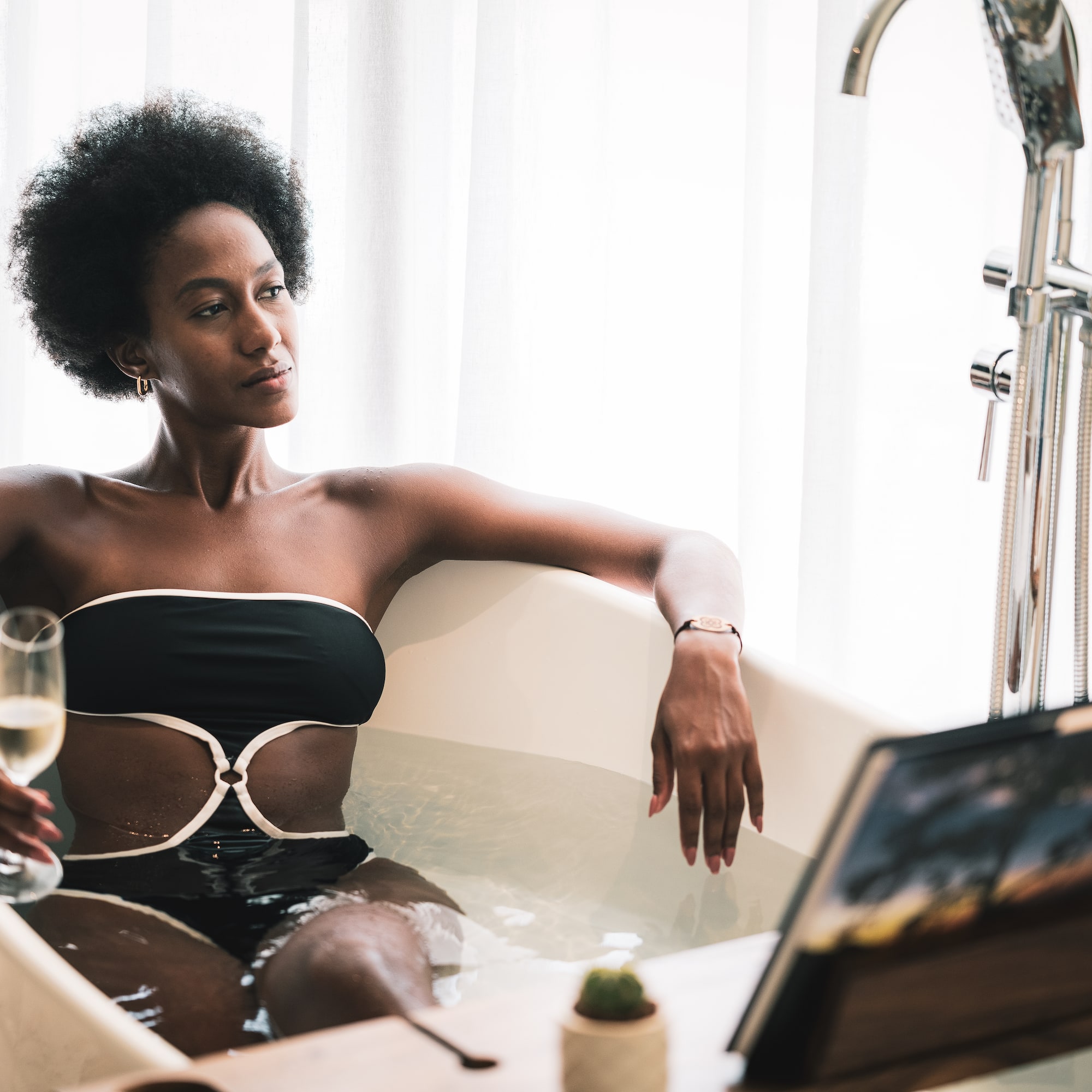 a woman in a bathtub holding a glass of wine