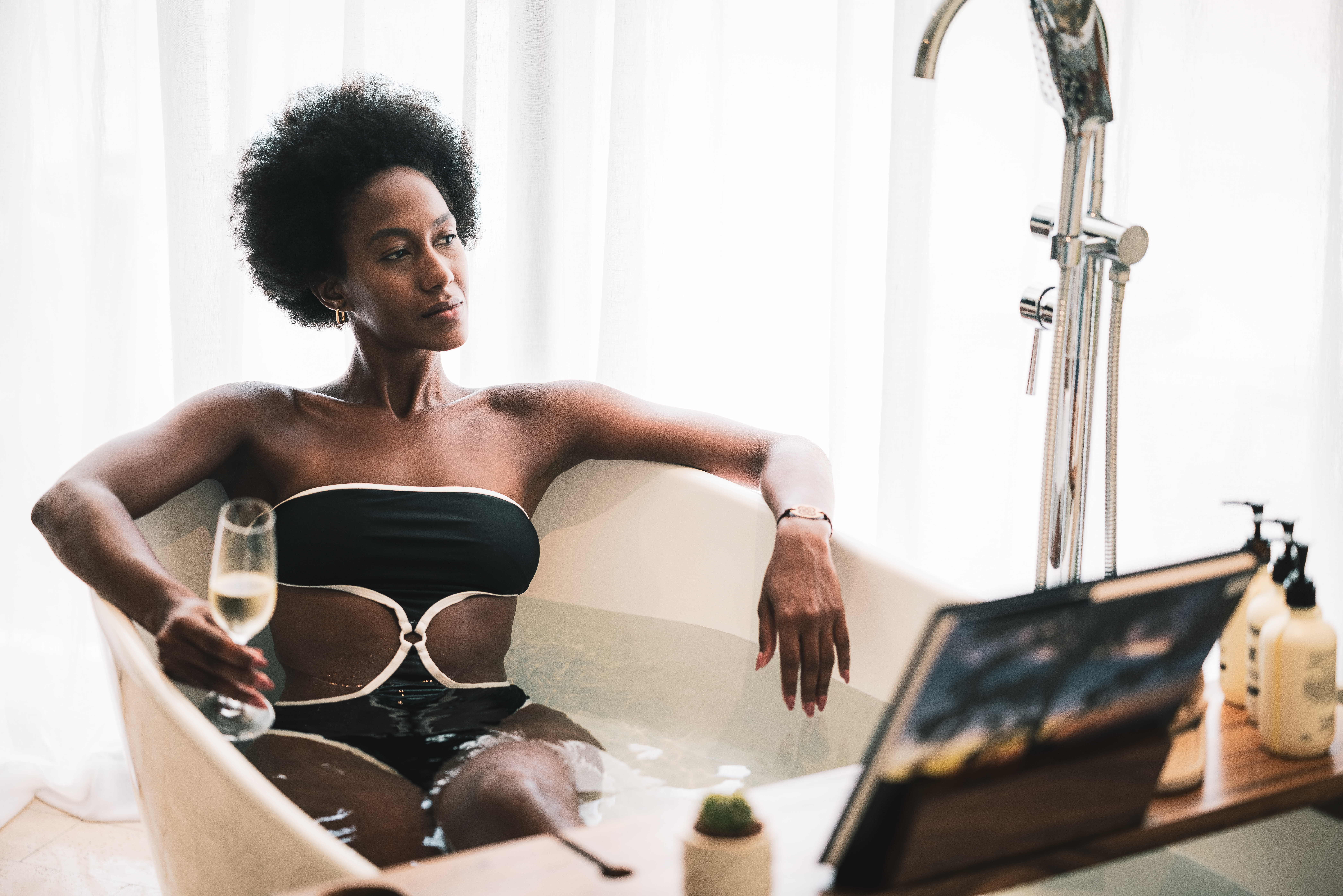 a woman in a bathtub holding a glass of wine