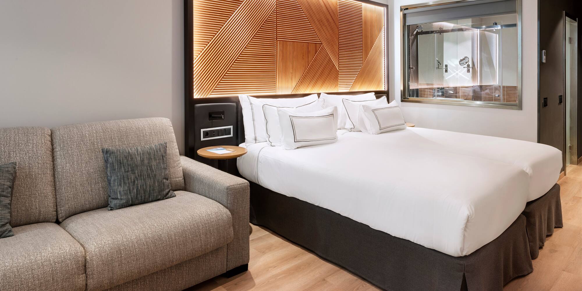 a bed with pillows and a chair in a room