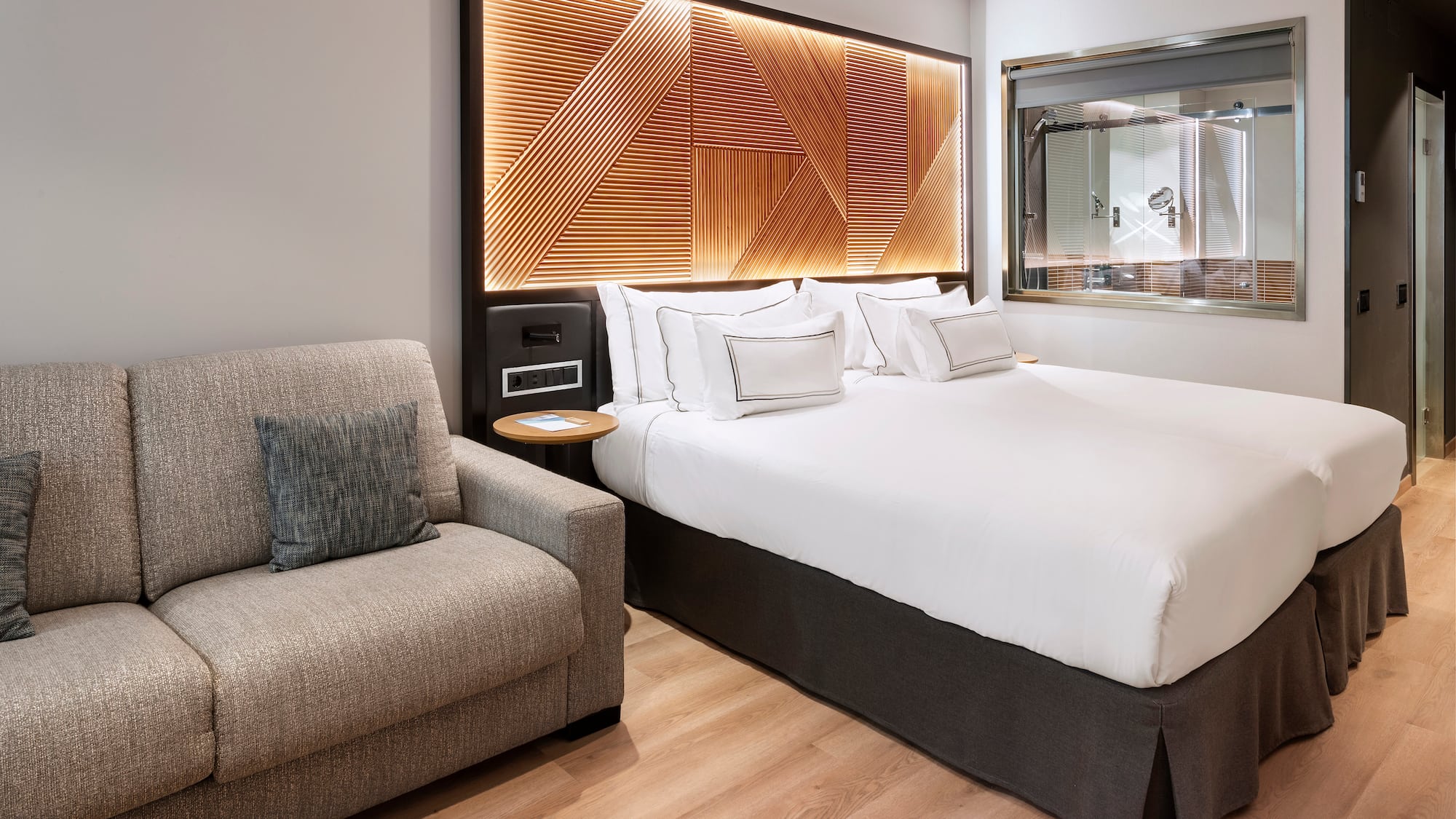 a bed with pillows and a chair in a room