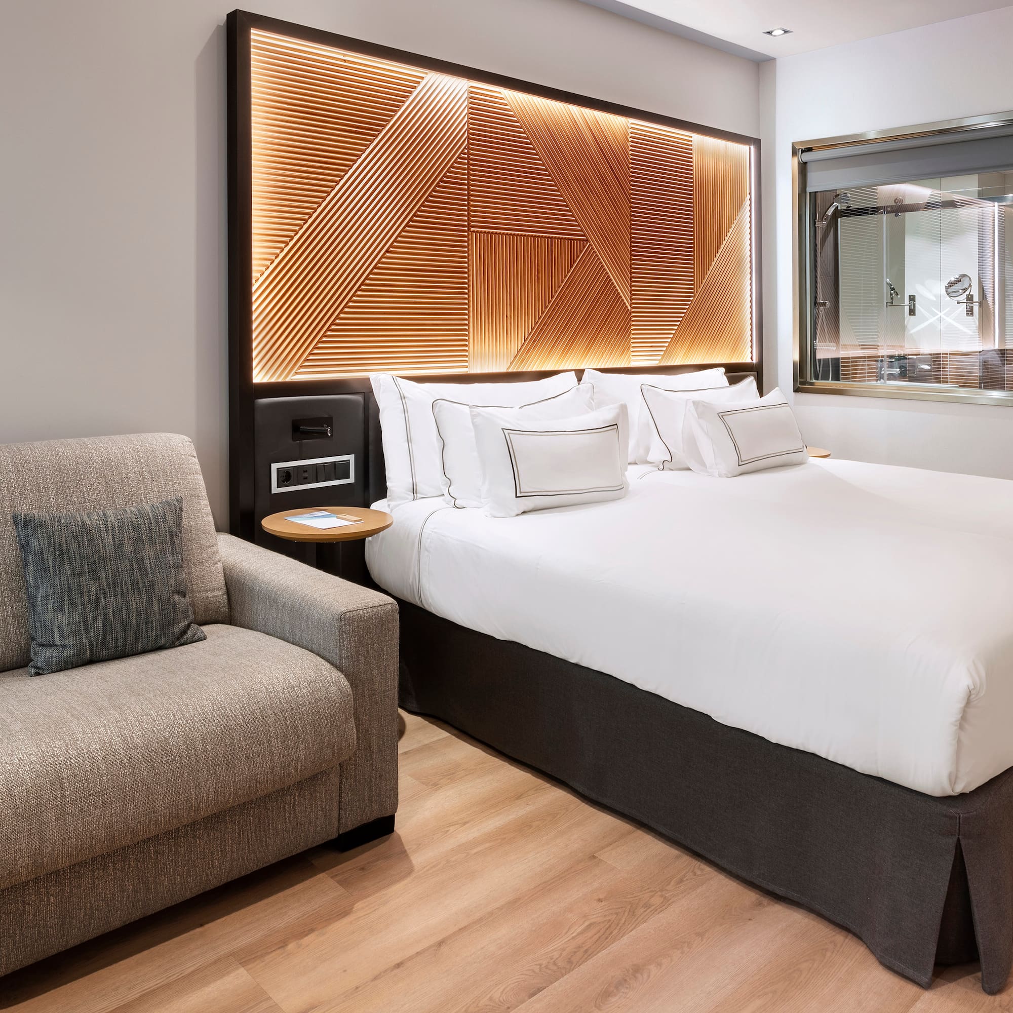 a bed with pillows and a chair in a room