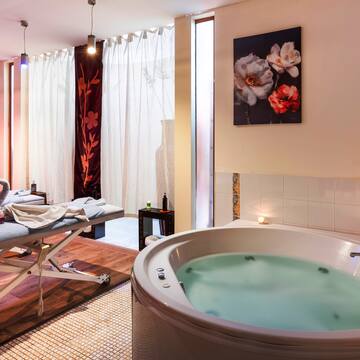 a room with a hot tub and massage table