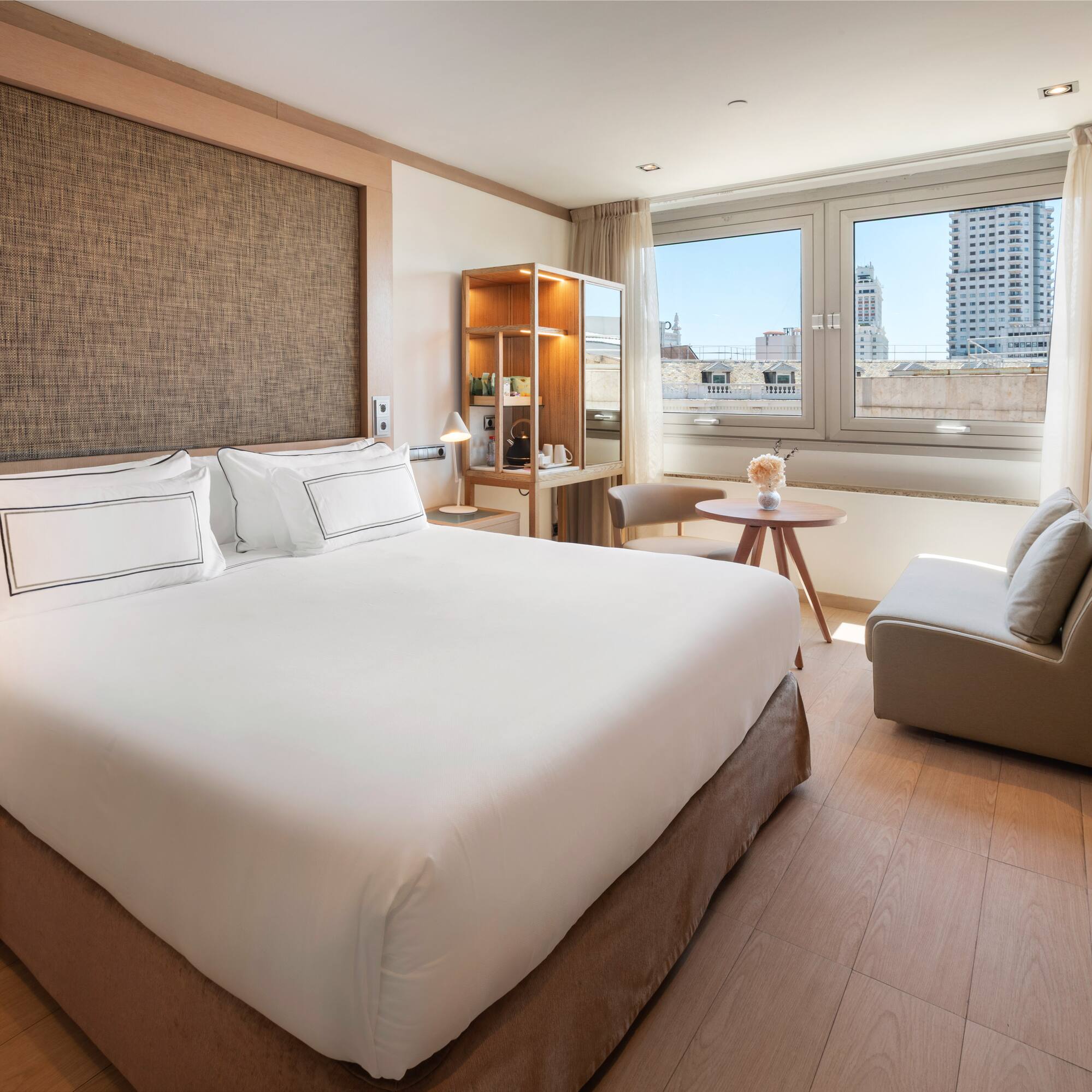 a bedroom with a large bed and a table and chairs