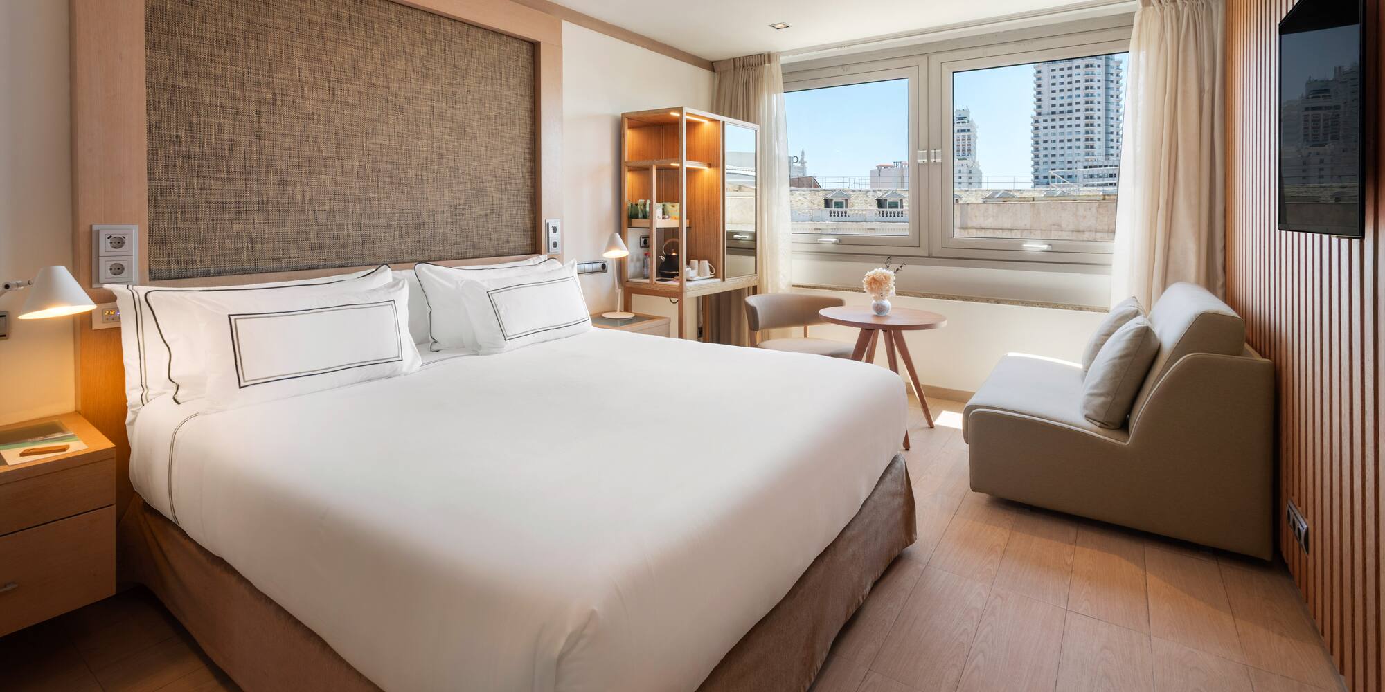 a bedroom with a large bed and a table and chairs