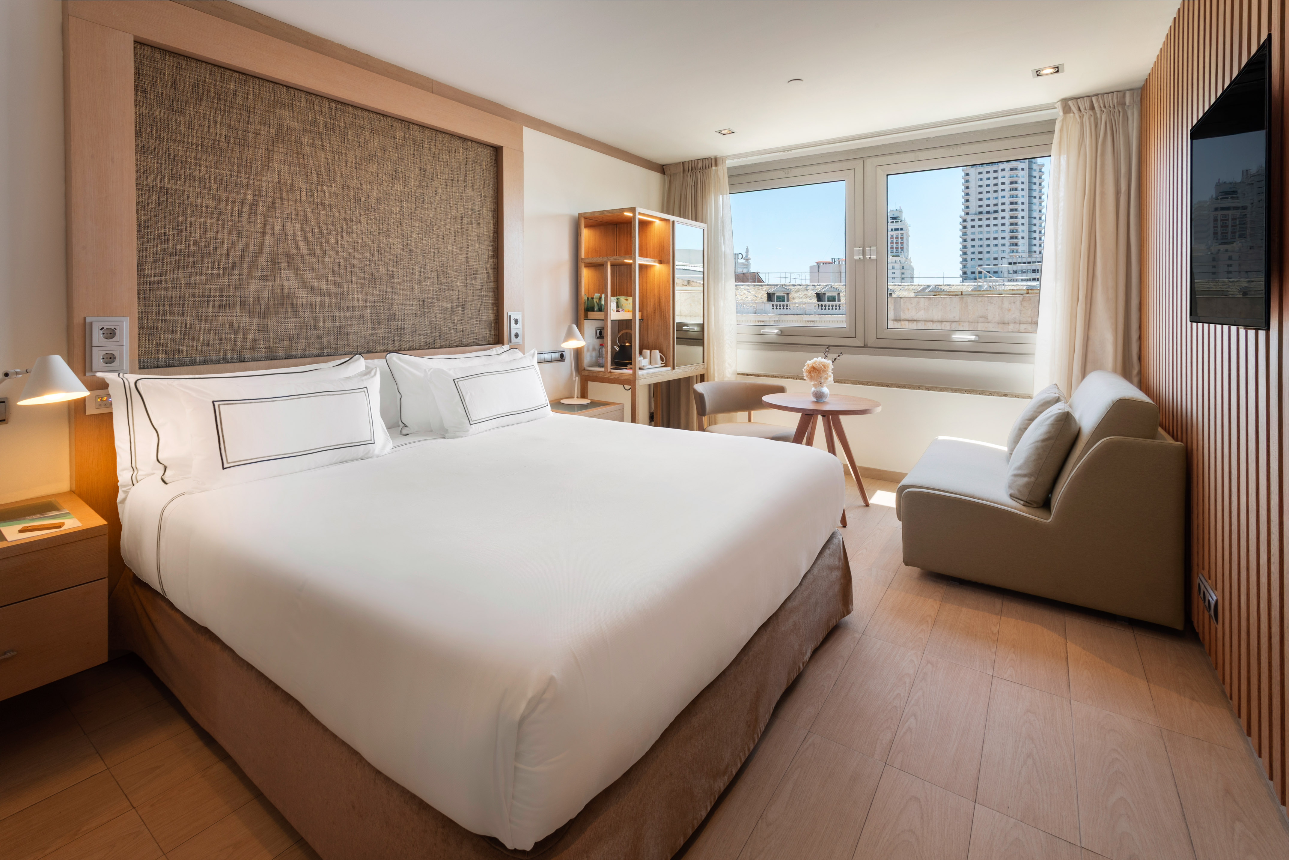 a bedroom with a large bed and a table and chairs