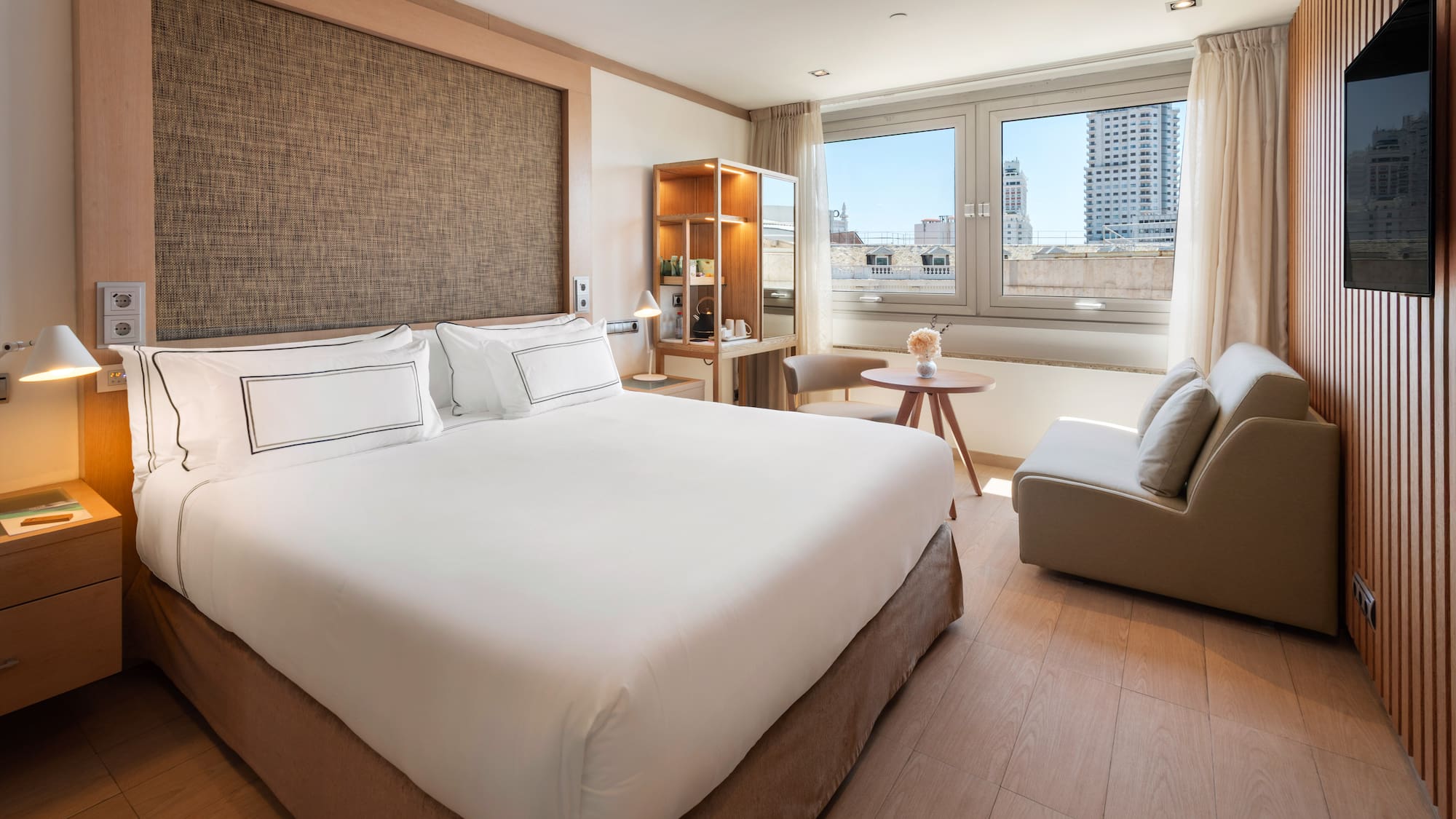 a bedroom with a large bed and a table and chairs