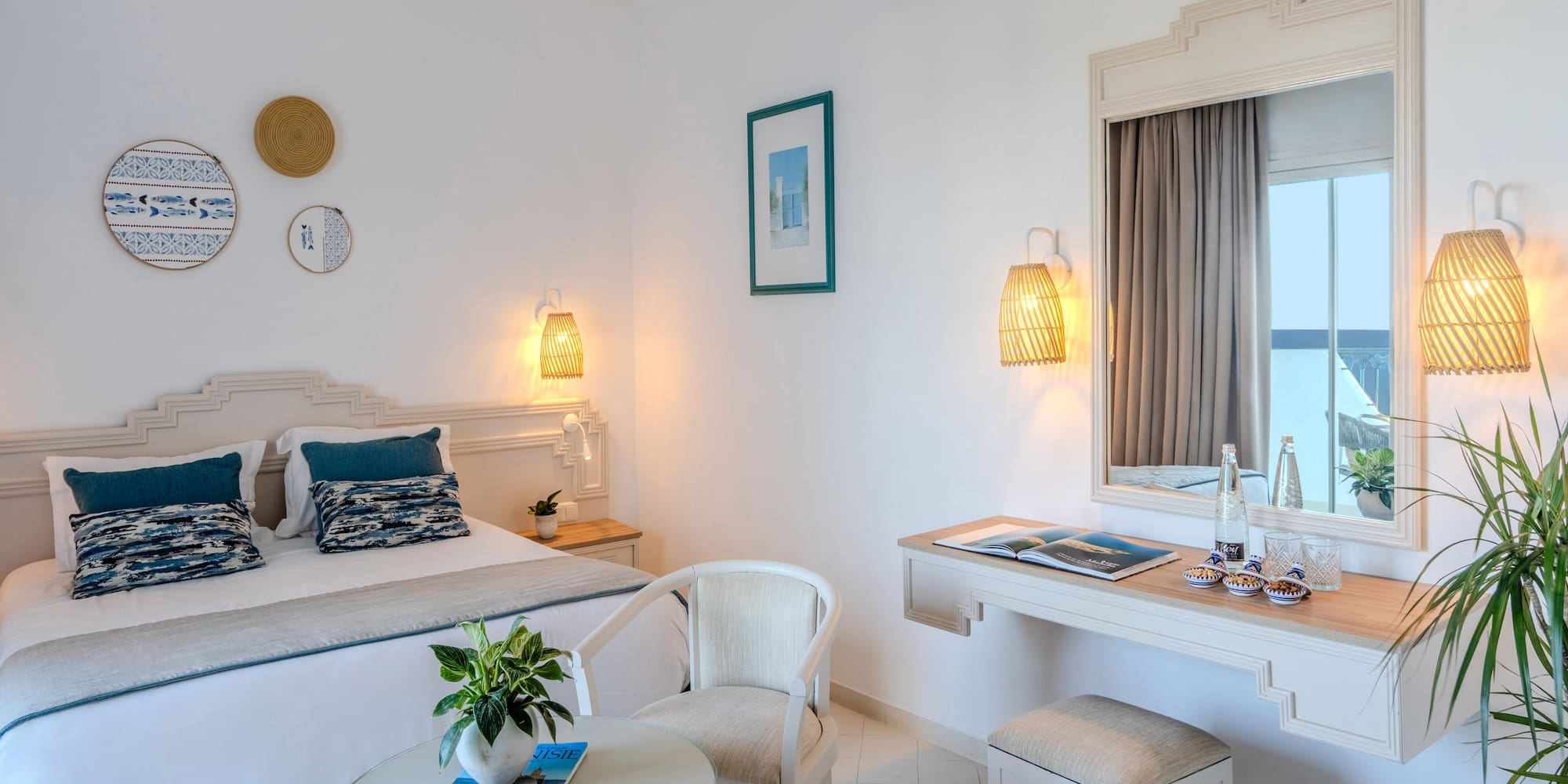 Mediterranean hotel bedroom with white walls, blue accents, and woven decor.