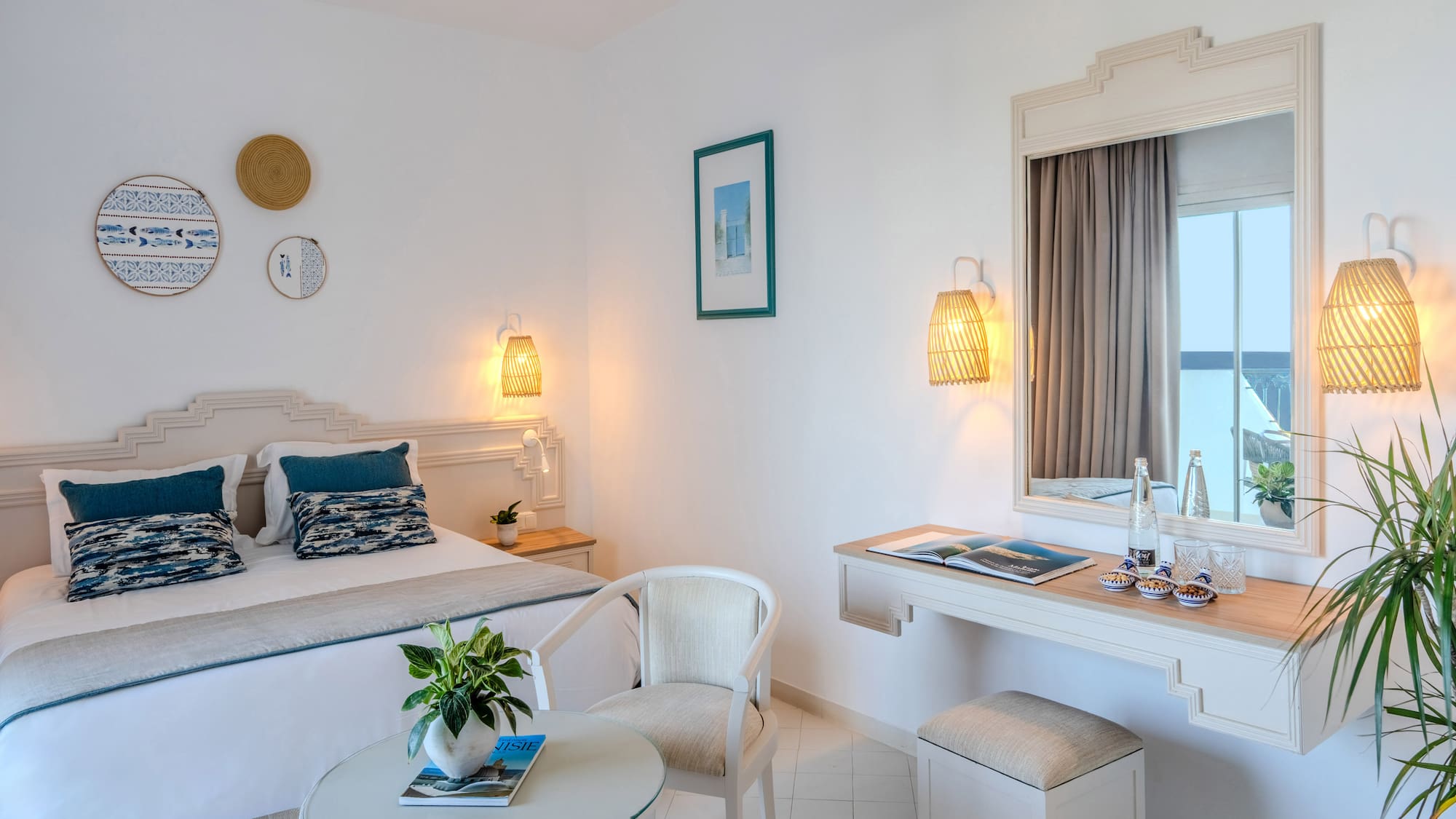 Mediterranean hotel bedroom with white walls, blue accents, and woven decor.