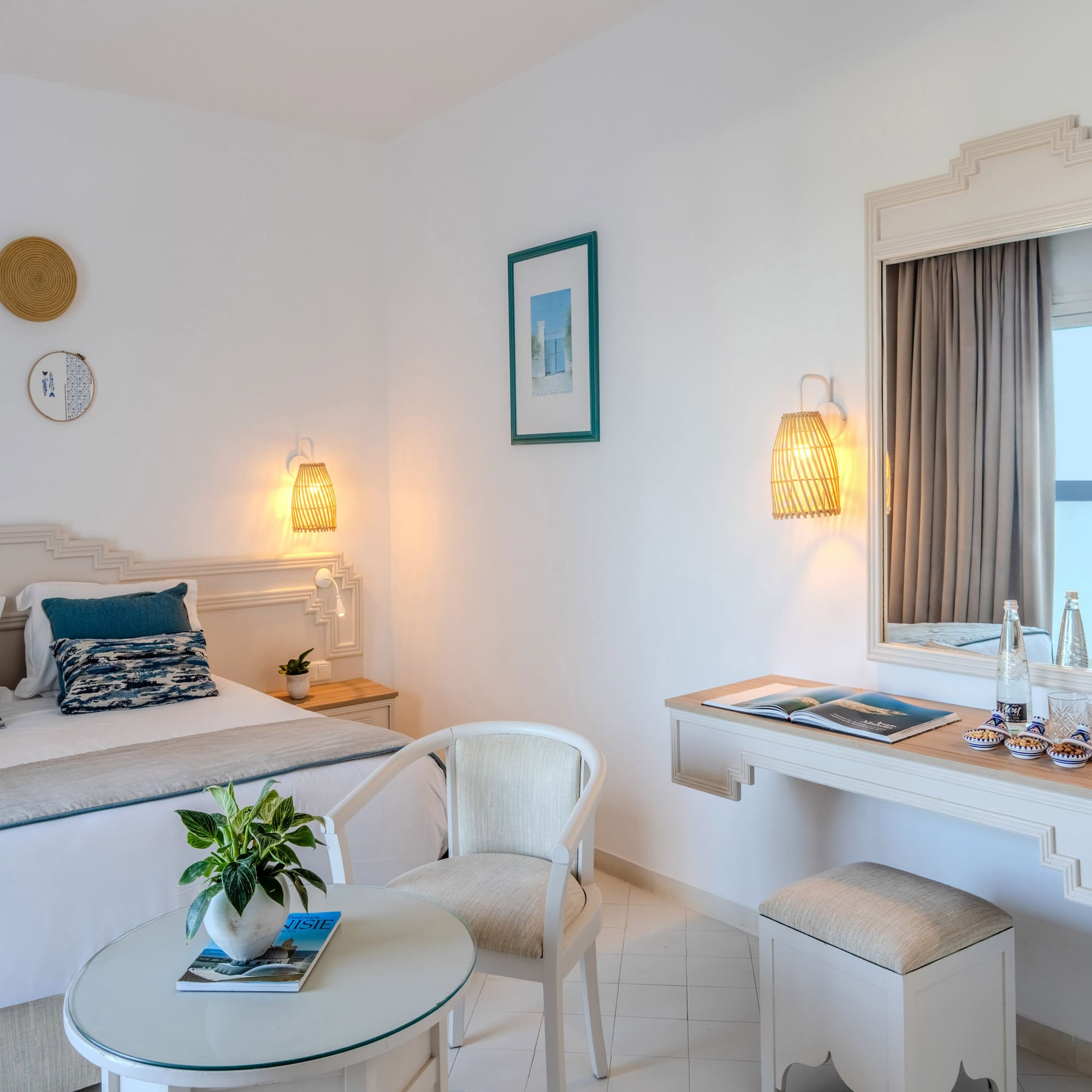 Mediterranean hotel bedroom with white walls, blue accents, and woven decor.